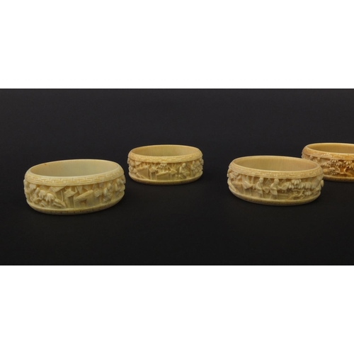 627 - Group of seven oriental Chinese Canton ivory napkin rings carved with figures, pagodas and trees, ea... 