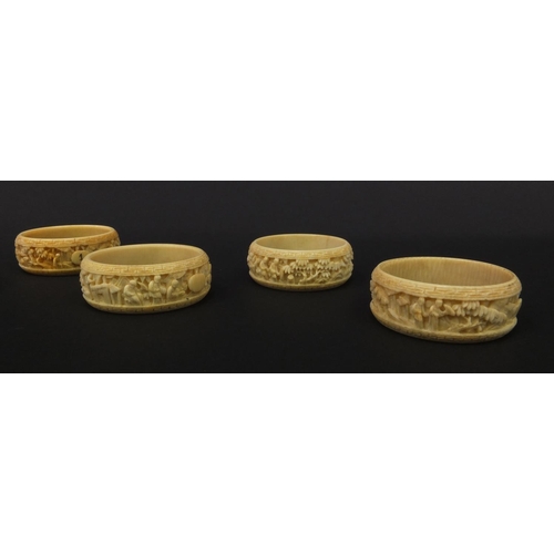 627 - Group of seven oriental Chinese Canton ivory napkin rings carved with figures, pagodas and trees, ea... 