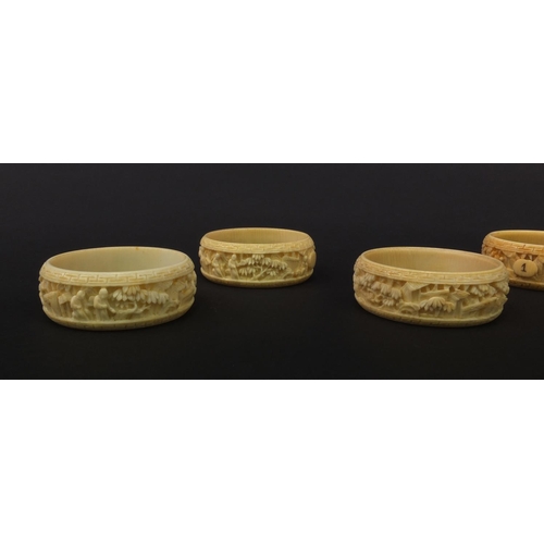 627 - Group of seven oriental Chinese Canton ivory napkin rings carved with figures, pagodas and trees, ea... 