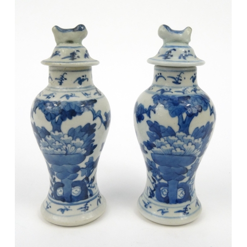 556 - Pair of oriental Chinese porcelain vases and covers hand painted with flowers, each 15cm high