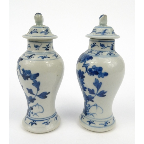 556 - Pair of oriental Chinese porcelain vases and covers hand painted with flowers, each 15cm high