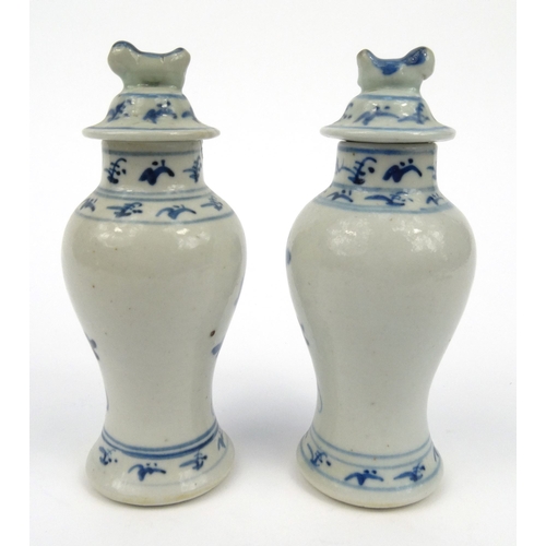 556 - Pair of oriental Chinese porcelain vases and covers hand painted with flowers, each 15cm high