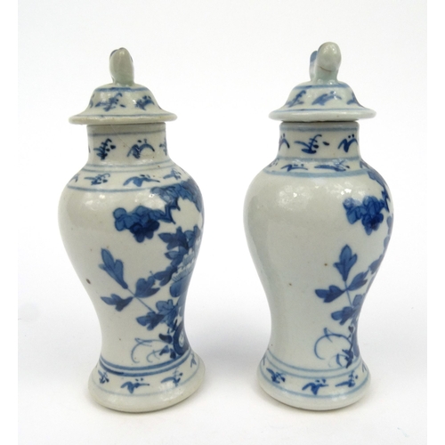 556 - Pair of oriental Chinese porcelain vases and covers hand painted with flowers, each 15cm high