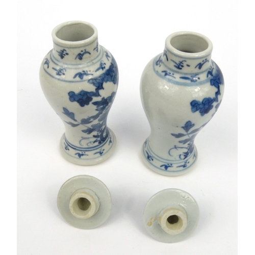 556 - Pair of oriental Chinese porcelain vases and covers hand painted with flowers, each 15cm high