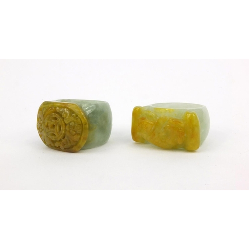 639 - Two oriental Chinese jade thumb rings - one carved with a lion, the other with bats, 3.5cm diameter