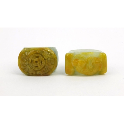 639 - Two oriental Chinese jade thumb rings - one carved with a lion, the other with bats, 3.5cm diameter