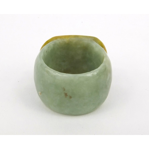 639 - Two oriental Chinese jade thumb rings - one carved with a lion, the other with bats, 3.5cm diameter