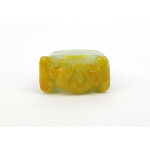 639 - Two oriental Chinese jade thumb rings - one carved with a lion, the other with bats, 3.5cm diameter