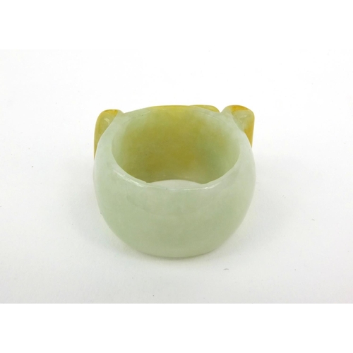 639 - Two oriental Chinese jade thumb rings - one carved with a lion, the other with bats, 3.5cm diameter