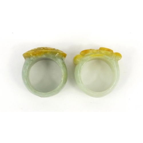 639 - Two oriental Chinese jade thumb rings - one carved with a lion, the other with bats, 3.5cm diameter