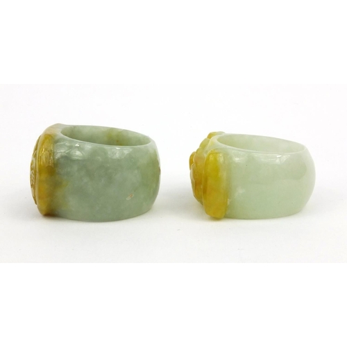 639 - Two oriental Chinese jade thumb rings - one carved with a lion, the other with bats, 3.5cm diameter