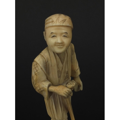 606 - Oriental Japanese ivory okimono figure of a gentleman with a stick, 15.5cm high