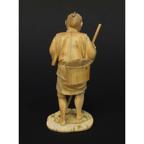 605 - Oriental Japanese ivory okimono of a gentleman with a stick and a basket, 15.5cm high