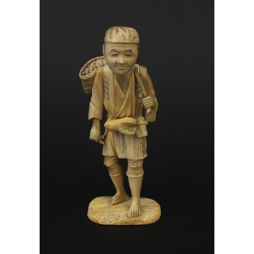 603 - Oriental Japanese ivory okimono of a fruit seller raised on a bone base, 15cm high