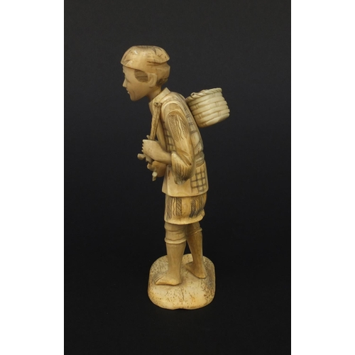 603 - Oriental Japanese ivory okimono of a fruit seller raised on a bone base, 15cm high