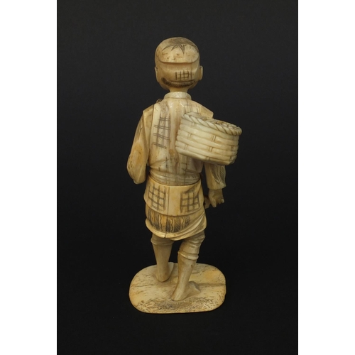 603 - Oriental Japanese ivory okimono of a fruit seller raised on a bone base, 15cm high