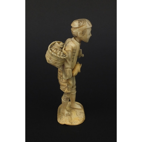 603 - Oriental Japanese ivory okimono of a fruit seller raised on a bone base, 15cm high