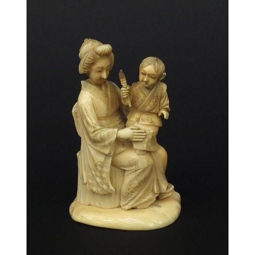 607 - Oriental Japanese ivory okimono of a mother and child holding a flaming torch, red character mark to... 