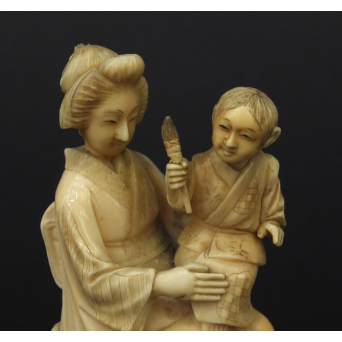 607 - Oriental Japanese ivory okimono of a mother and child holding a flaming torch, red character mark to... 