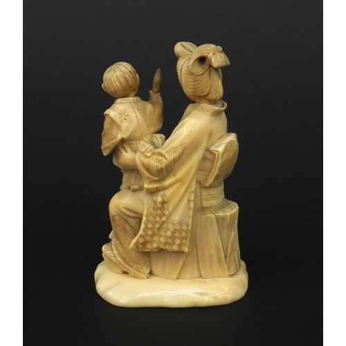 607 - Oriental Japanese ivory okimono of a mother and child holding a flaming torch, red character mark to... 