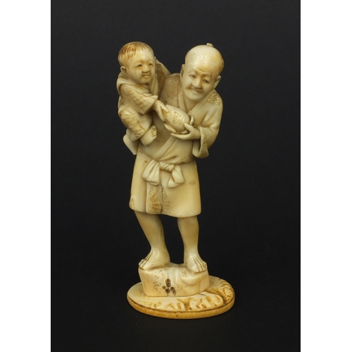 608 - Oriental Japanese ivory okimono of a father and young child holding fruit, 10cm high