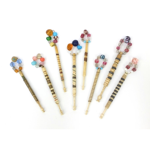 95 - Eight sewing interest antique bone lace bobbins with beaded glass tops