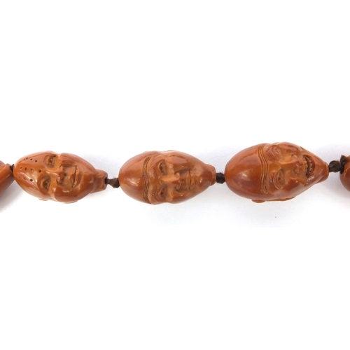 532 - Chinese carved coquilla nut necklace, the nuts each carved with different expressive faces, the neck... 