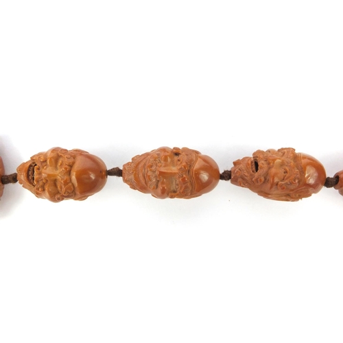 532 - Chinese carved coquilla nut necklace, the nuts each carved with different expressive faces, the neck... 