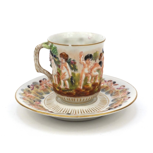 593 - Naples hand painted cup and saucer decorated with relief with continuous band of figures carrying a ... 