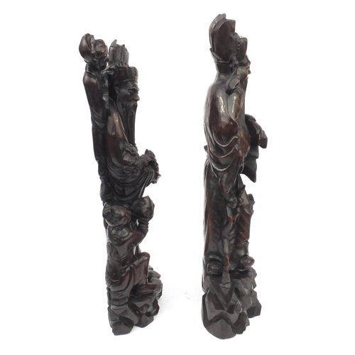 551 - Large pair of Chinese carved root figures, both of elders with children, the tallest 62cm high