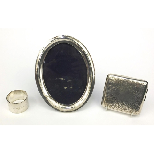 772 - Silver items comprising of an oval easel photo frame, cigarette case with floral chased decoration a... 