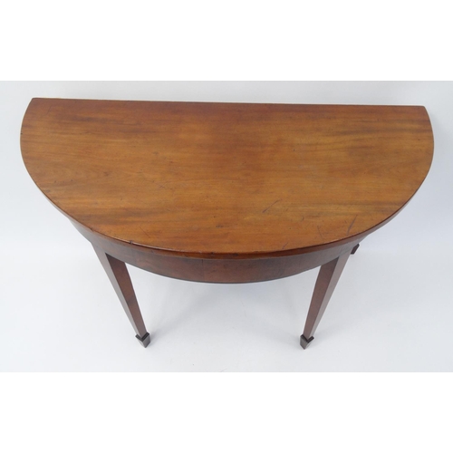 25 - Georgian mahogany demi lune hall table raised on tapering legs, 69cm high x 110cm wide x 52cm deep