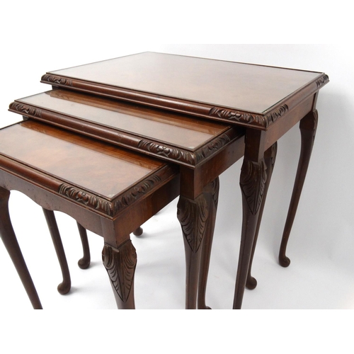 85 - Nest of three carved burr walnut occasional tables with glass tops