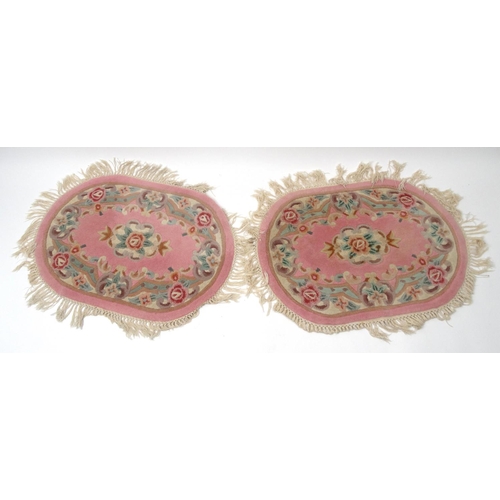 154 - Pair of oval pink ground floral rugs, approximately  94cm x 64cm