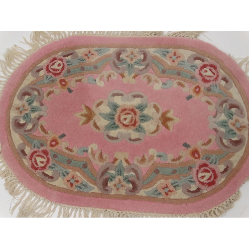 154 - Pair of oval pink ground floral rugs, approximately  94cm x 64cm