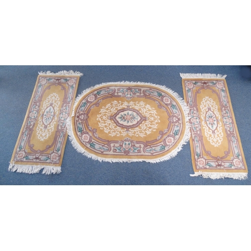 95 - Pair of rectangular butterscotch ground floral rugs an oval example, the larger approximately 185cm ... 