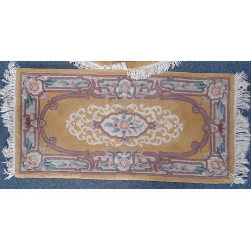 95 - Pair of rectangular butterscotch ground floral rugs an oval example, the larger approximately 185cm ... 