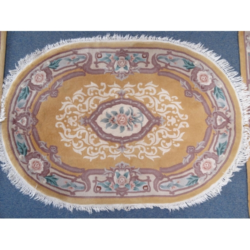 95 - Pair of rectangular butterscotch ground floral rugs an oval example, the larger approximately 185cm ... 