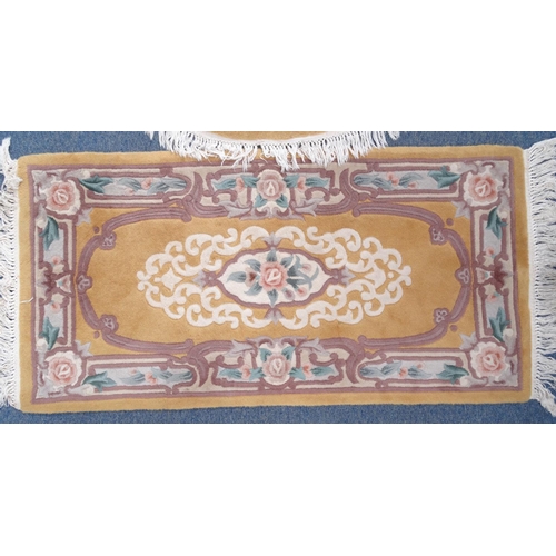 95 - Pair of rectangular butterscotch ground floral rugs an oval example, the larger approximately 185cm ... 