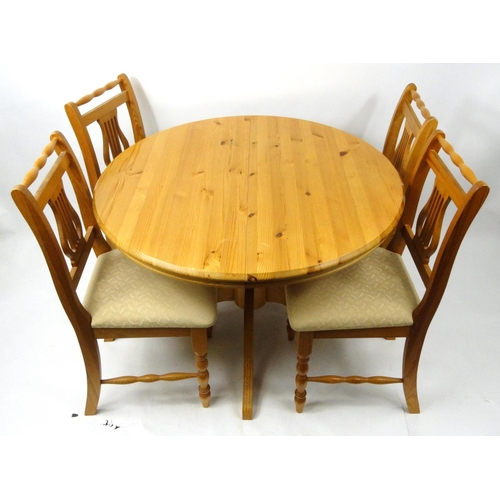 11 - Circular pine extending dining table with four lyre back chairs