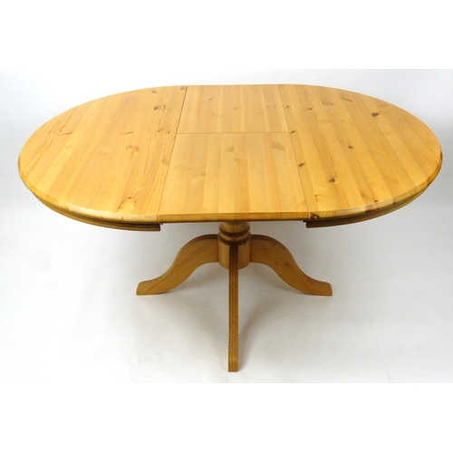 11 - Circular pine extending dining table with four lyre back chairs