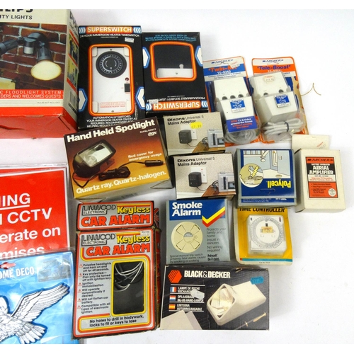 290 - Two boxes of mostly as new electrical items including security lights, 12v power station, timer swit... 