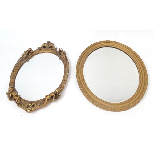 75 - Two ornate oval gilt framed mirrors, one with Putti decoration, the larger approximately 64cm x 41cm