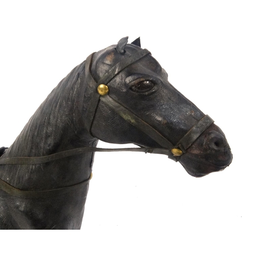 543 - Two leather model horses, the largest approximately 32cm high