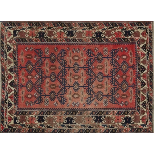 87 - Red ground geometric patterned carpet, approximately 275cm x 195cm