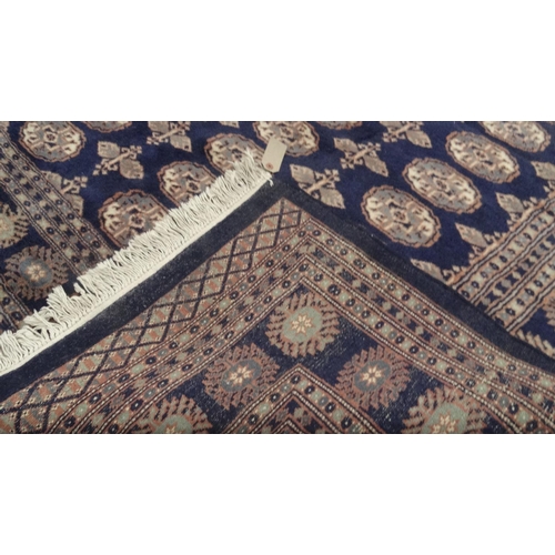 16 - Blue ground geometric patterned carpet, approximately 275cm x 185cm