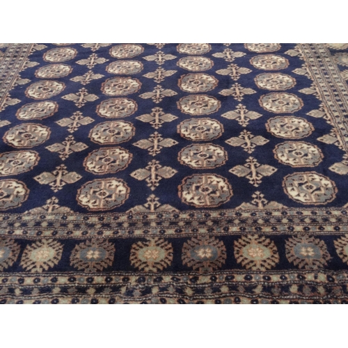 16 - Blue ground geometric patterned carpet, approximately 275cm x 185cm