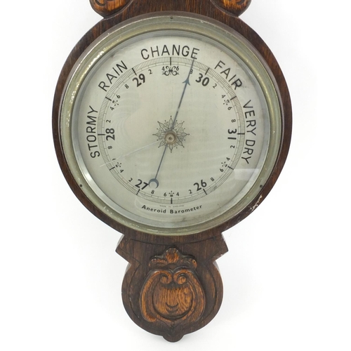 313 - Carved oak aneroid barometer with a presentation plaque, 84cm high