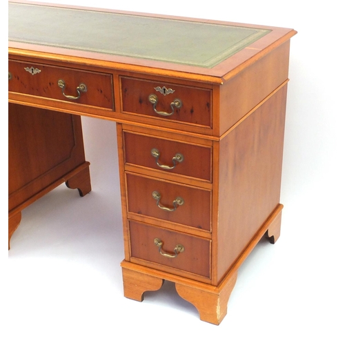 2004 - Yew wood twin pedestal desk with green tooled leather top, 79cm high x 121cm wide x 60cm deep