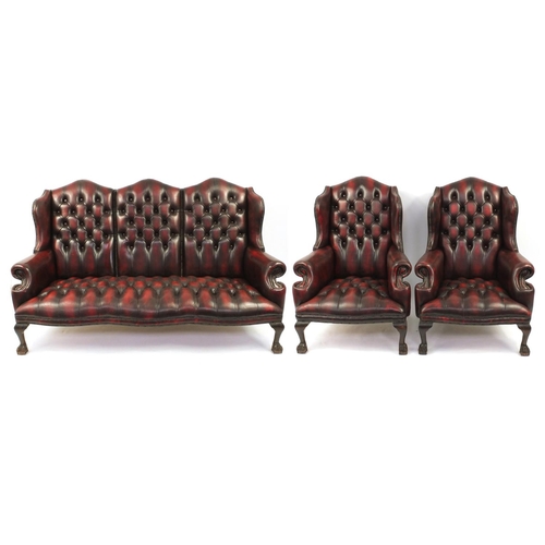 2003 - Chesterfield style burgundy leather three piece suite, comprising of a three seater wing back settee... 